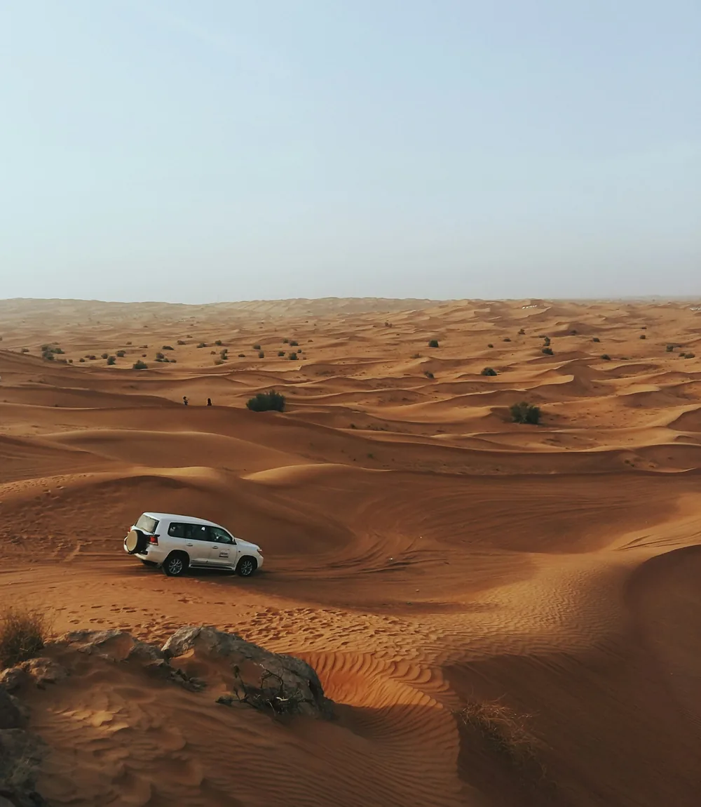 Otwarty jeep 4x4 przemierzający czerwone piaski pustyni Wadi Rum